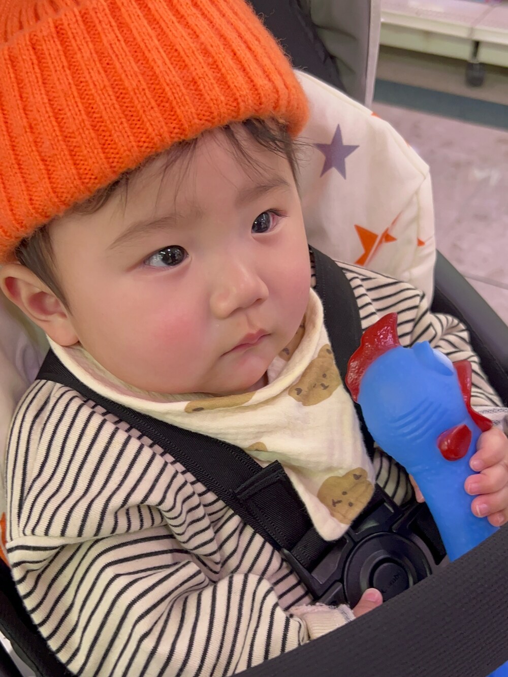 ベージュ系のスウェット、ブルー系のパンツ、オレンジ系のニットキャップ/ビーニーを着用したキッズの冬コーディネートの2枚目の写真