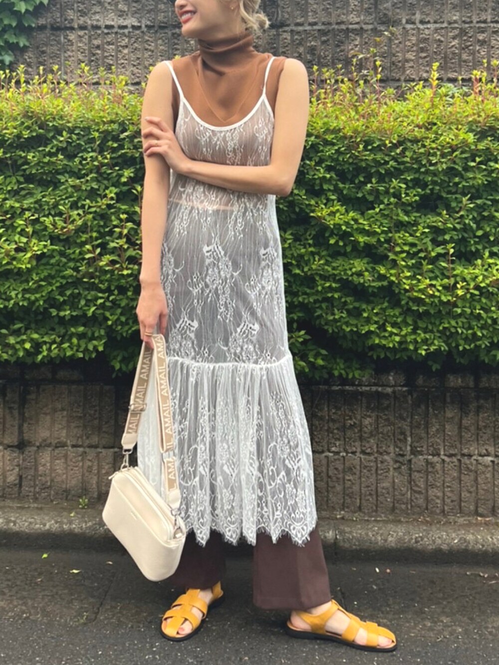 ホワイト系のワンピース、ブラウン系のTシャツ/カットソー、ベージュ系のショルダーバッグを着用したレディースの春コーディネートの4枚目の写真