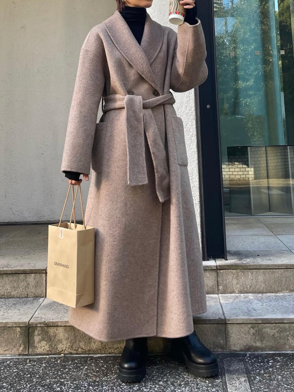 ベージュ系のダウンジャケット/コート、ブラック系のニット/セーターを着用したレディースの冬コーディネートの2枚目の写真