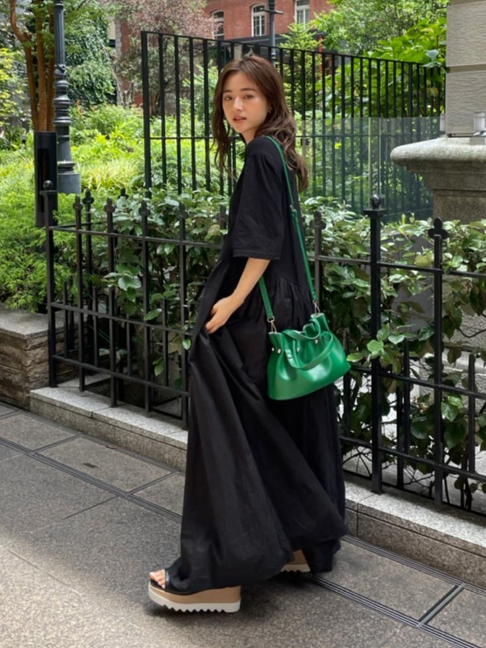 ブラック系のワンピース、ブラック系のサンダルを着用したレディースの夏コーディネートの2枚目の写真