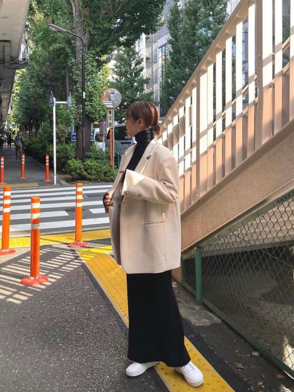 ブラック系のワンピース、ホワイト系のテーラードジャケットを着用したレディースの秋コーディネートの2枚目の写真