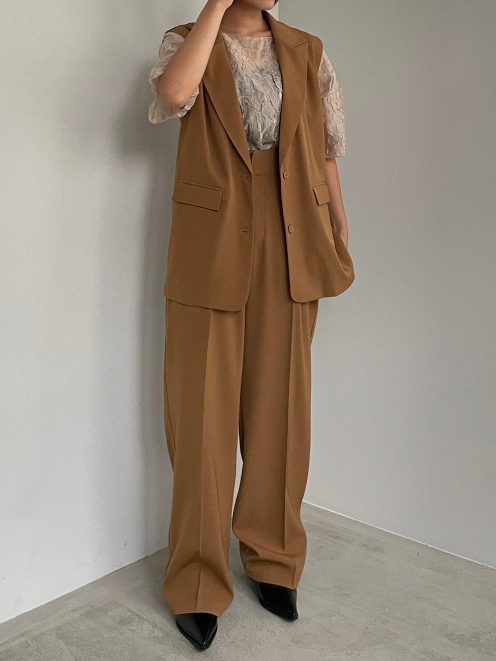 ブラウン系のベスト、ブラック系のショルダーバッグ、ブラウン系のその他パンツを着用したレディースの秋コーディネートの3枚目の写真