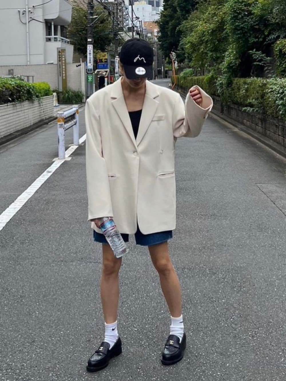 ホワイト系のテーラードジャケット、ブルー系のデニムパンツを着用したレディースの秋コーディネートの3枚目の写真