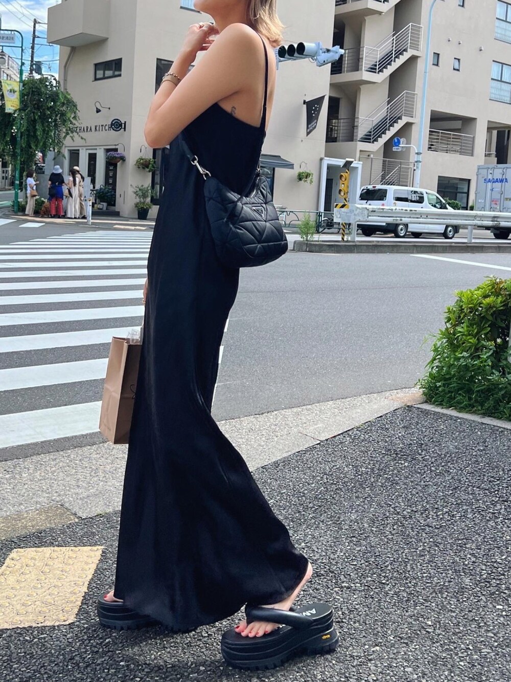 ブラック系のワンピースを着用したレディースの夏コーディネートの2枚目の写真