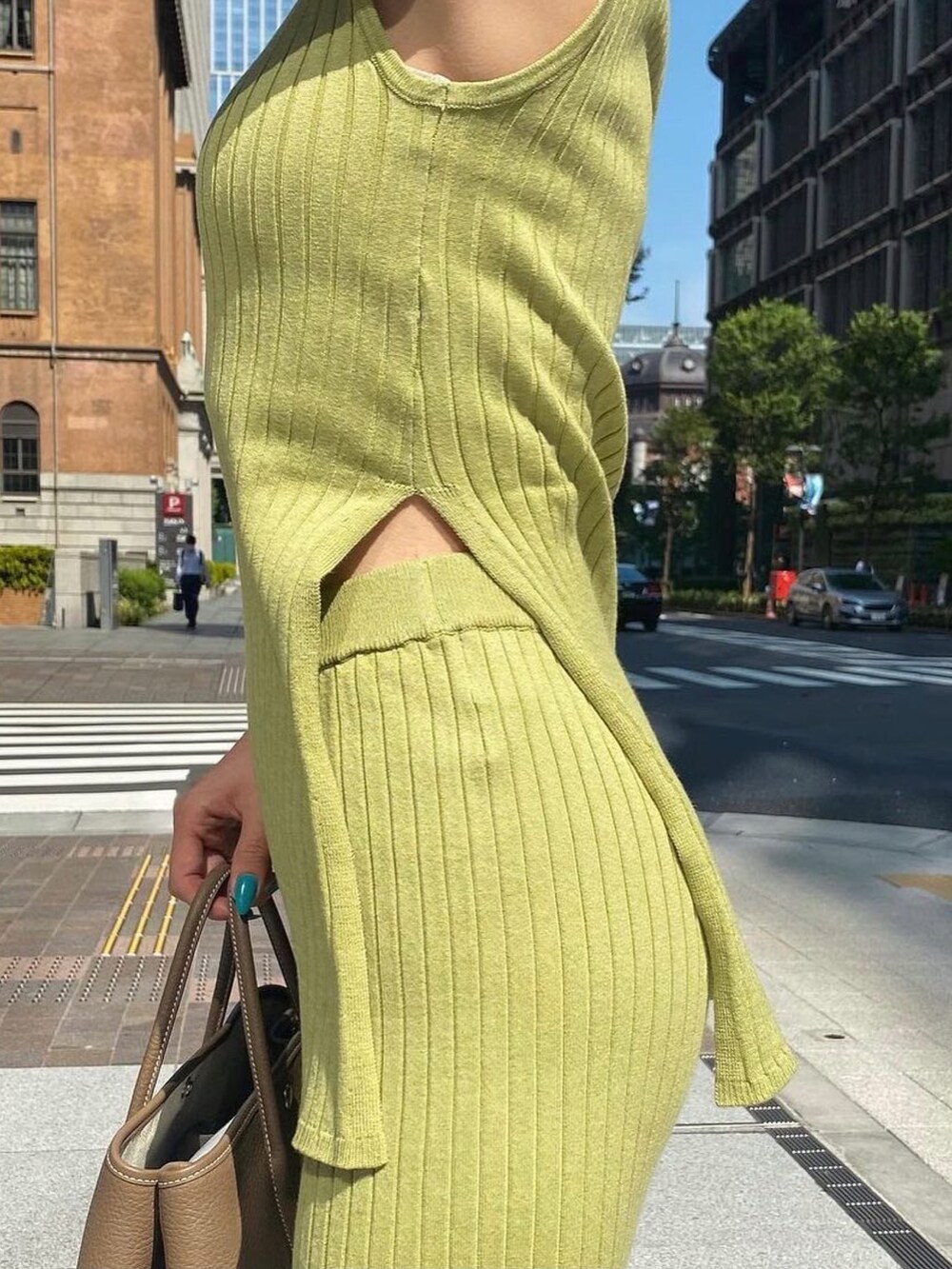 グリーン系のタンクトップを着用したレディースの夏コーディネートの3枚目の写真