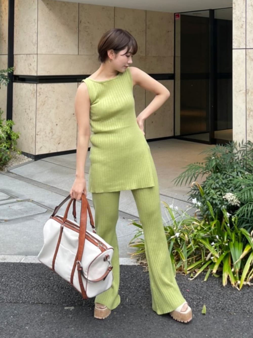 グリーン系のタンクトップ、ベージュ系のサンダル、ホワイト系のボストンバッグを着用したレディースの夏コーディネートの3枚目の写真