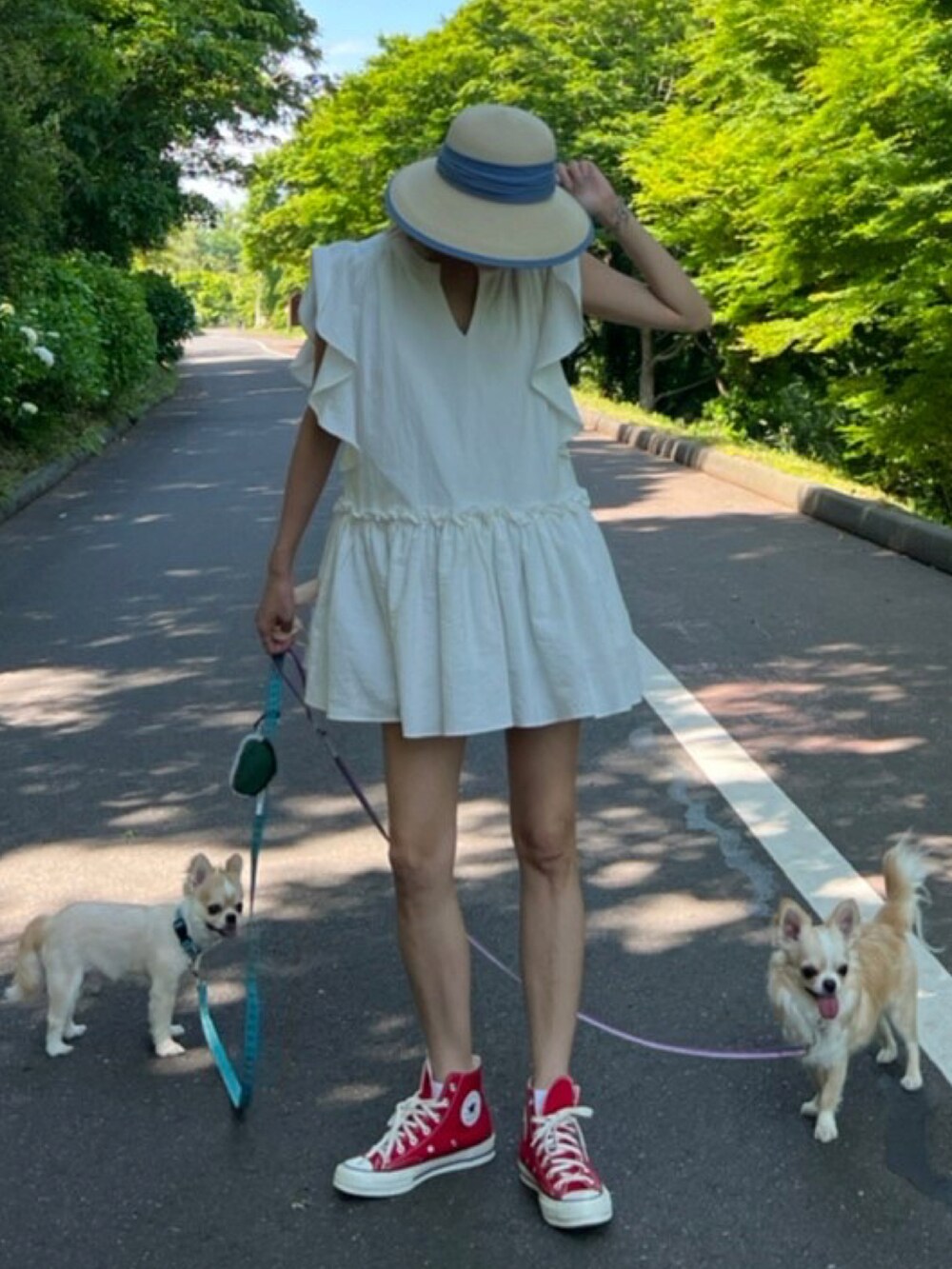 ホワイト系のワンピース、ブルー系のハットを着用したレディースの夏コーディネートの2枚目の写真