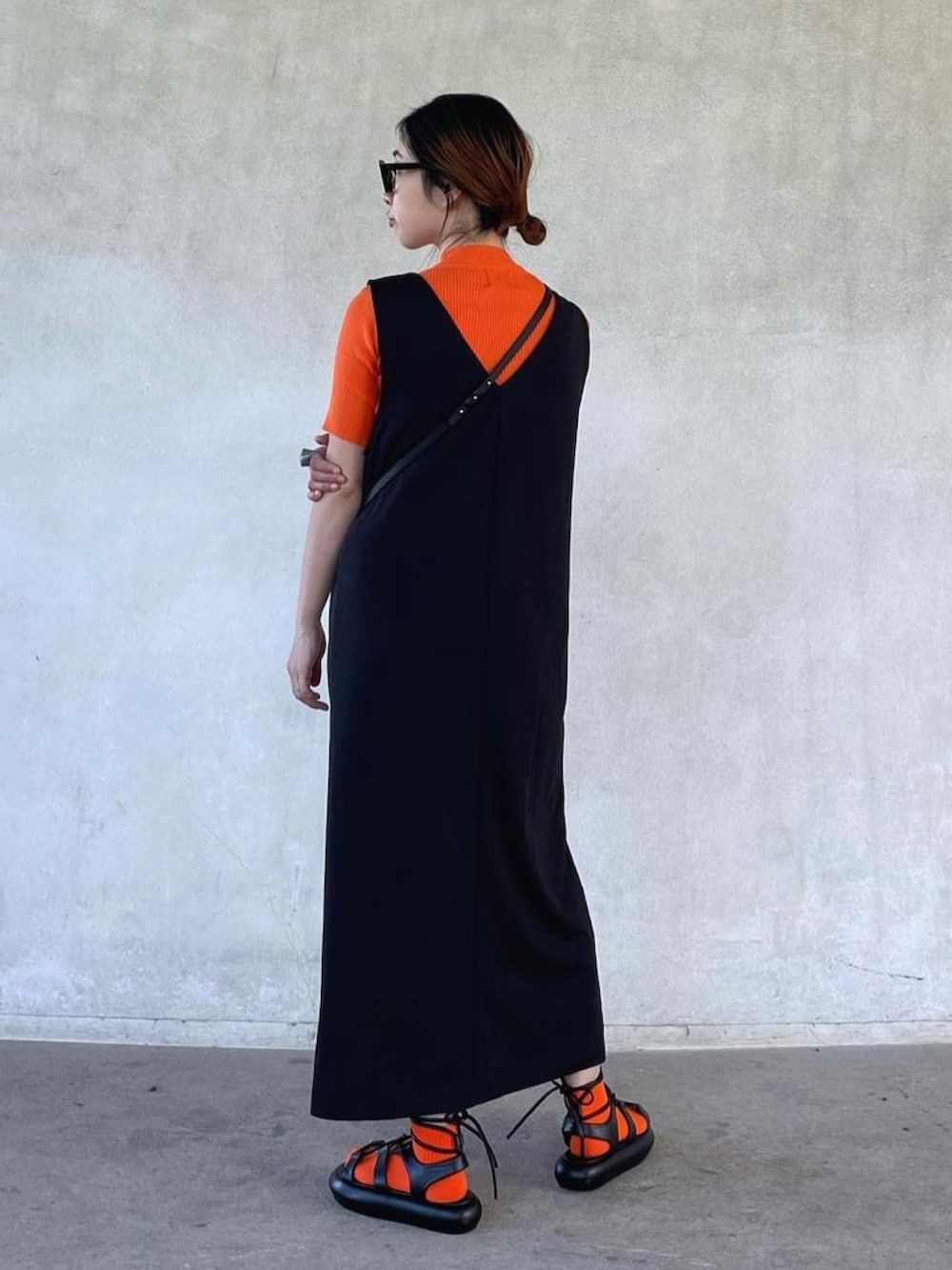 オレンジ系のTシャツ/カットソー、ブラック系のサンダルを着用したレディースの春コーディネートの2枚目の写真