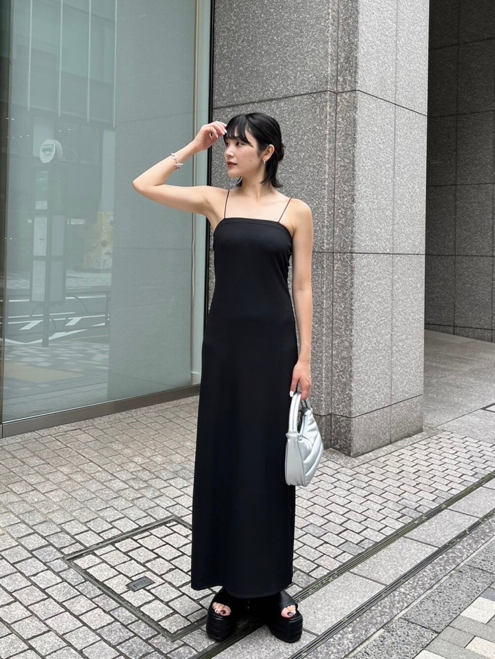 ブラック系のサンダル、シルバー系のハンドバッグ、ブラック系のワンピースを着用したレディースの夏コーディネートの3枚目の写真
