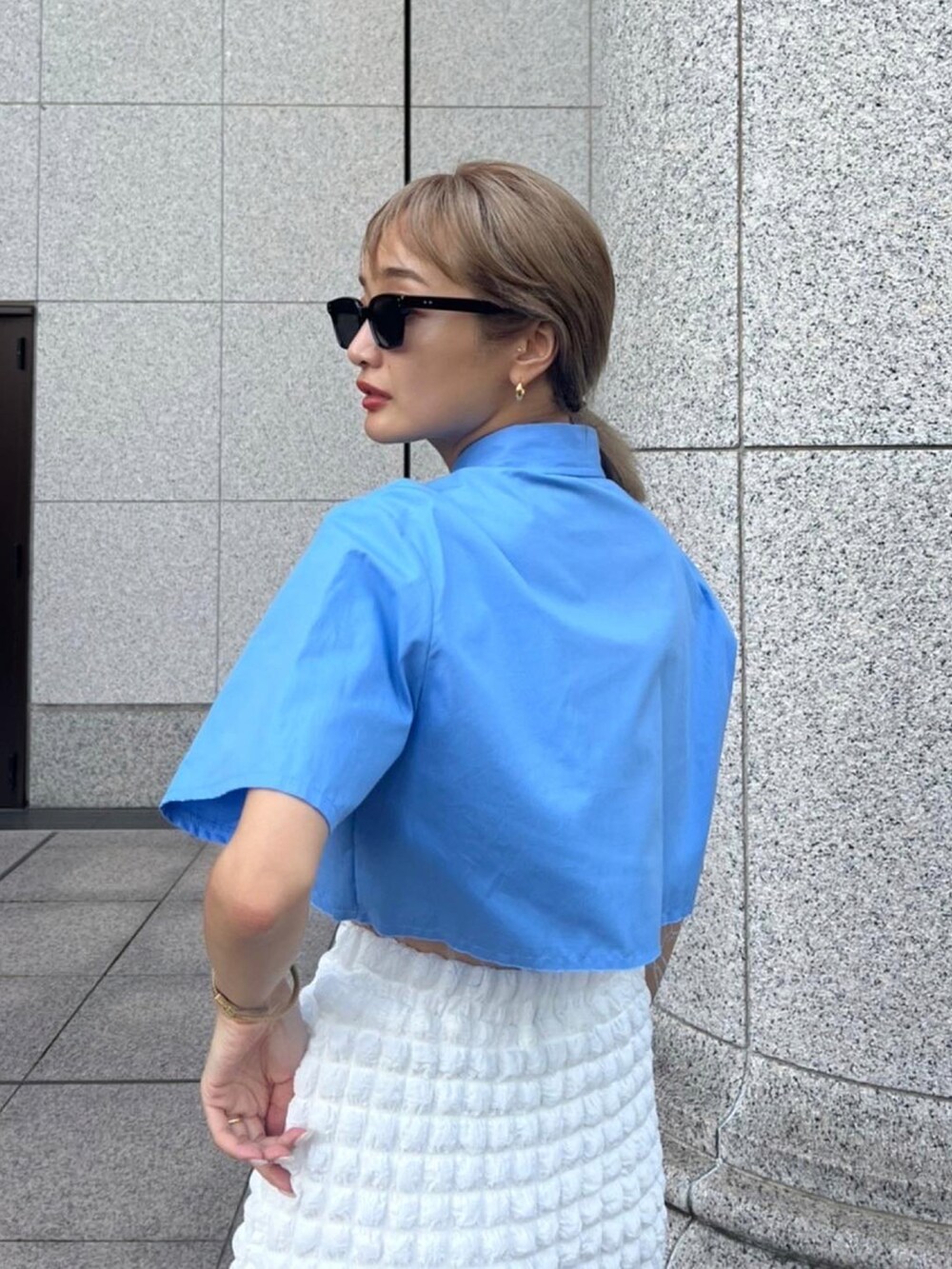 ブルー系のシャツ/ブラウス、ホワイト系のスカート、ホワイト系のショルダーバッグを着用したレディースの秋コーディネートの2枚目の写真