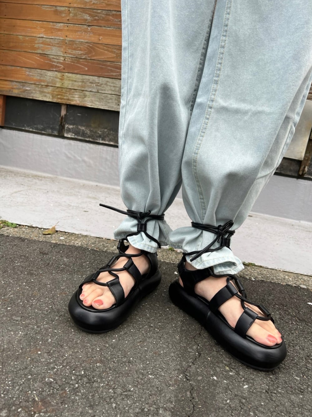 レッド系のタンクトップ、ブラック系のショルダーバッグ、ブラック系のサンダルを着用したレディースの春コーディネートの4枚目の写真