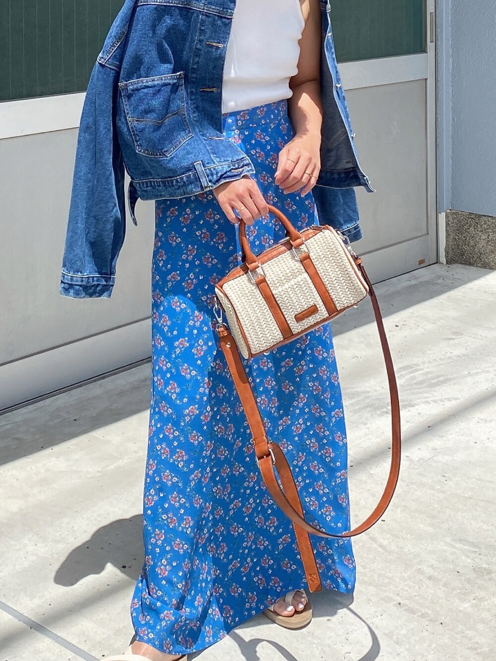 ホワイト系のショルダーバッグ、ブルー系のスカートを着用したレディースの夏コーディネートの2枚目の写真