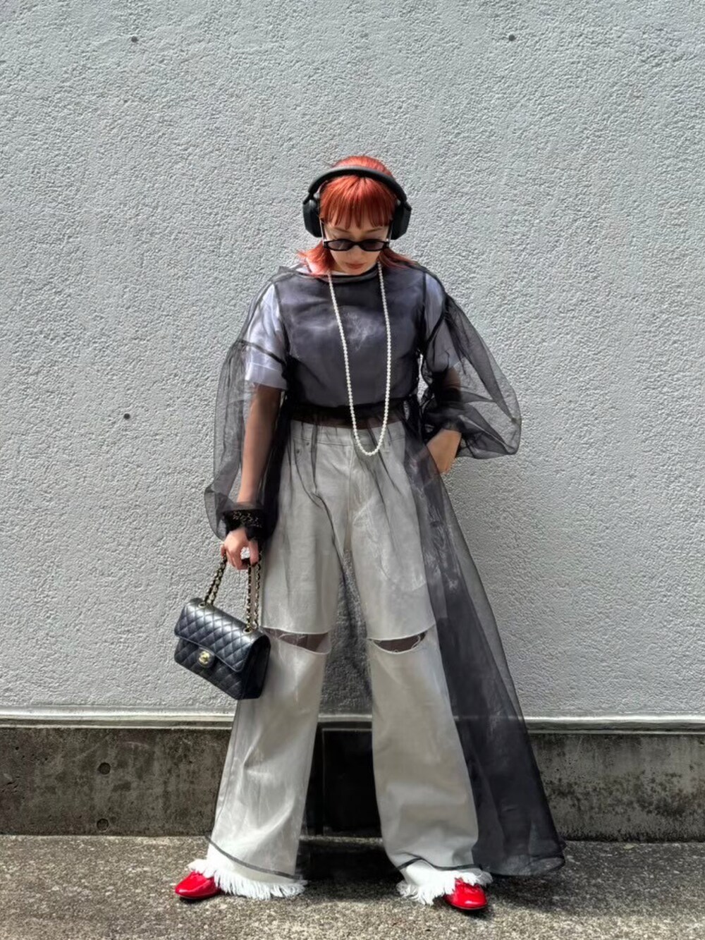 ブラック系のワンピース、ホワイト系のデニムパンツを着用したレディースの夏コーディネートの2枚目の写真