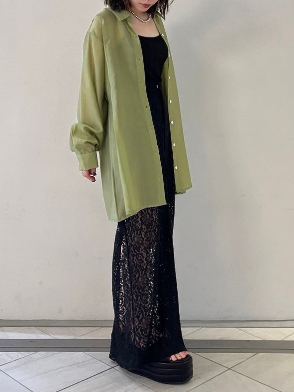 グリーン系のシャツ/ブラウス、ブラック系のサンダル、ブラック系のスカートを着用したレディースの夏コーディネートの2枚目の写真