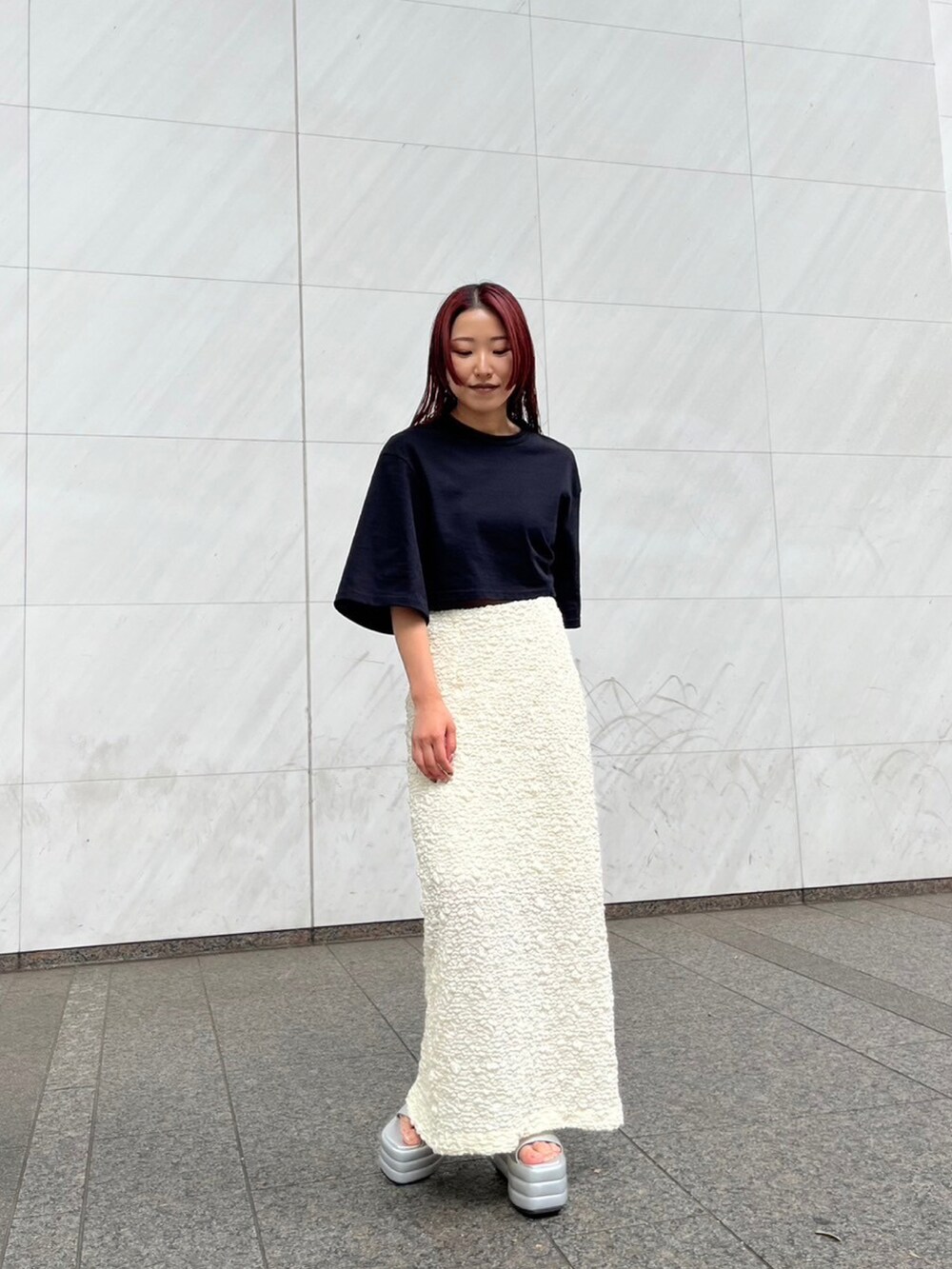 ブラック系のTシャツ/カットソー、ホワイト系のスカート、シルバー系のサンダルを着用したレディースの夏コーディネートの2枚目の写真