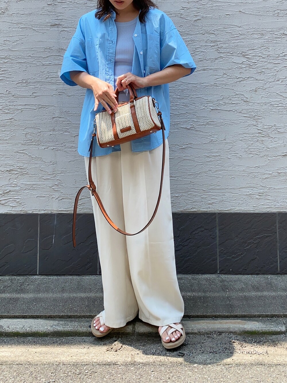 ホワイト系のショルダーバッグ、ブルー系のシャツ/ブラウスを着用したレディースの夏コーディネートの2枚目の写真