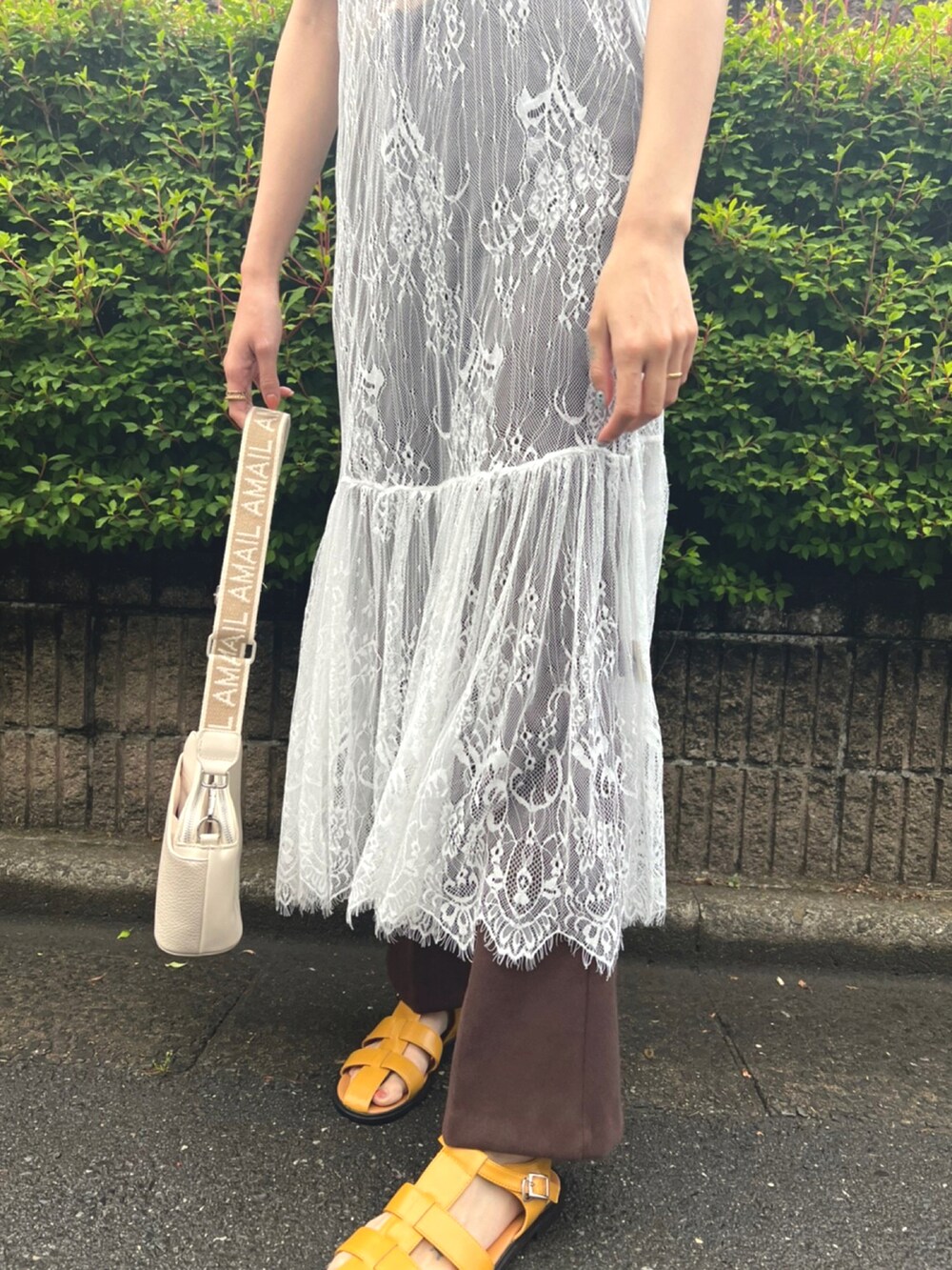 ホワイト系のワンピース、ブラウン系のTシャツ/カットソー、ベージュ系のショルダーバッグを着用したレディースの春コーディネートの3枚目の写真