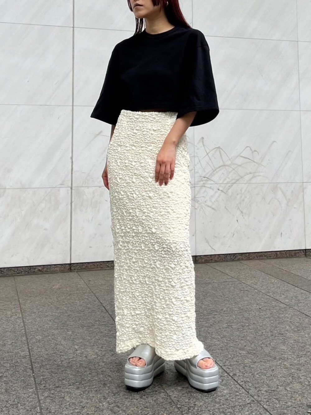 ブラック系のTシャツ/カットソー、ホワイト系のスカート、シルバー系のサンダルを着用したレディースの夏コーディネートの3枚目の写真