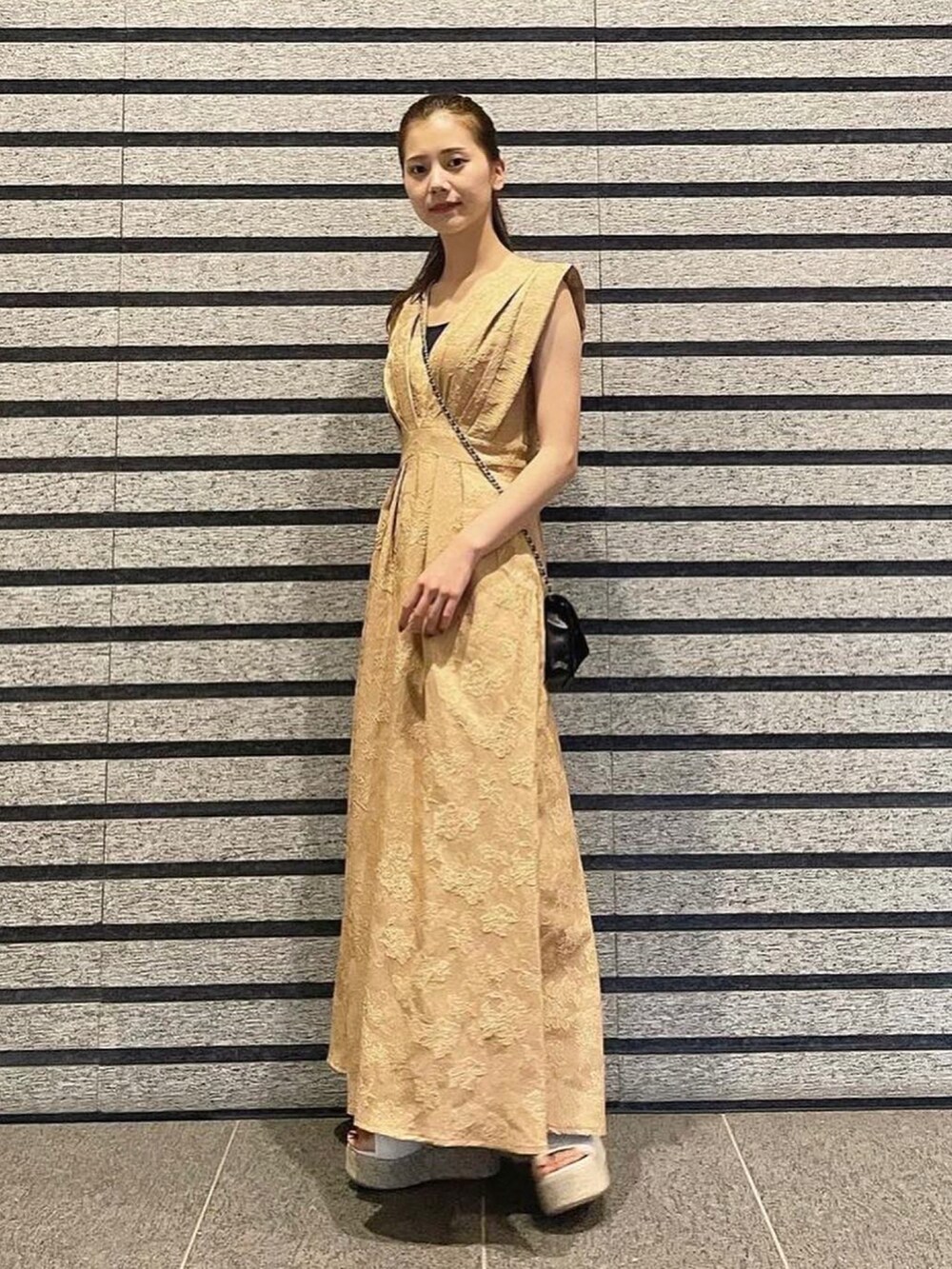 ベージュ系のワンピースを着用したレディースの夏コーディネートの2枚目の写真