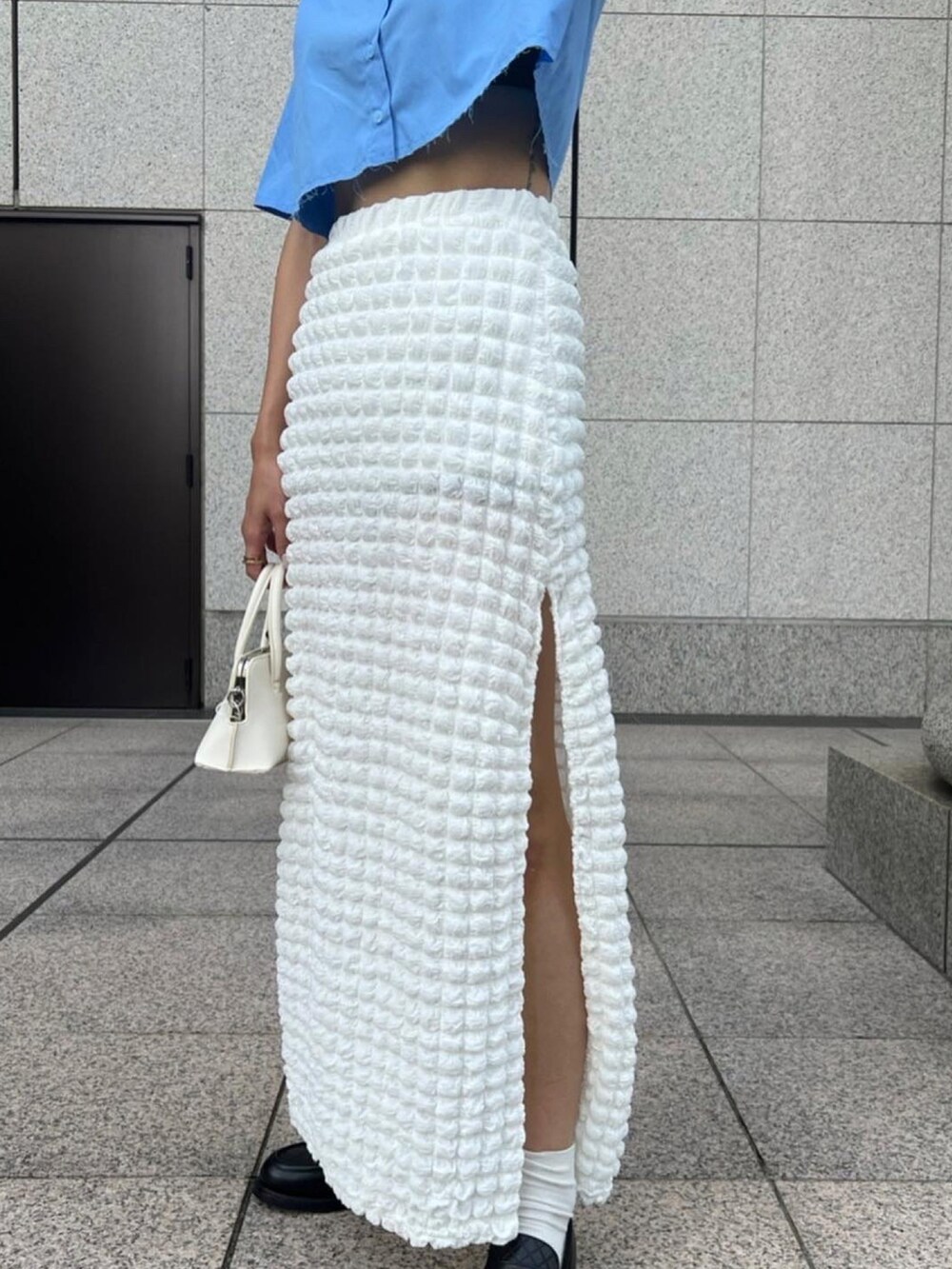 ブルー系のシャツ/ブラウス、ホワイト系のスカート、ホワイト系のショルダーバッグを着用したレディースの秋コーディネートの4枚目の写真