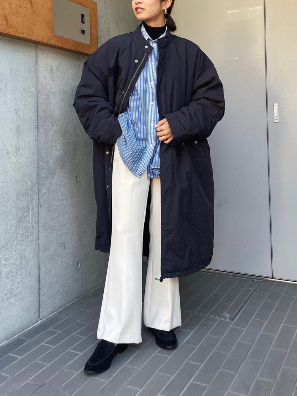 ブラック系のミリタリージャケットを着用したレディースの冬コーディネートの2枚目の写真