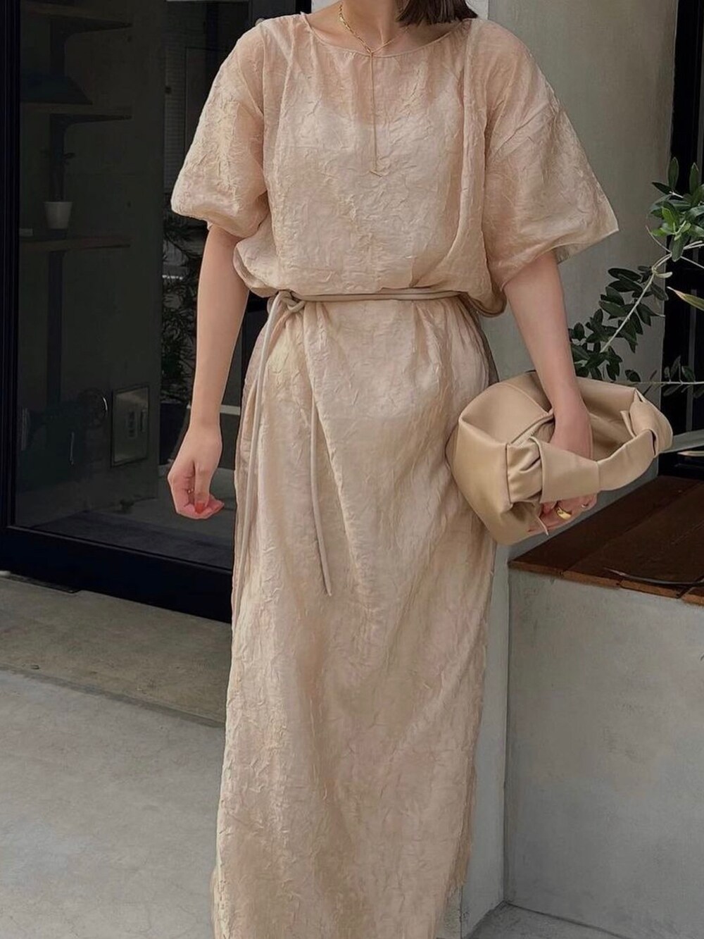 ベージュ系のワンピースを着用したレディースの秋コーディネートの2枚目の写真