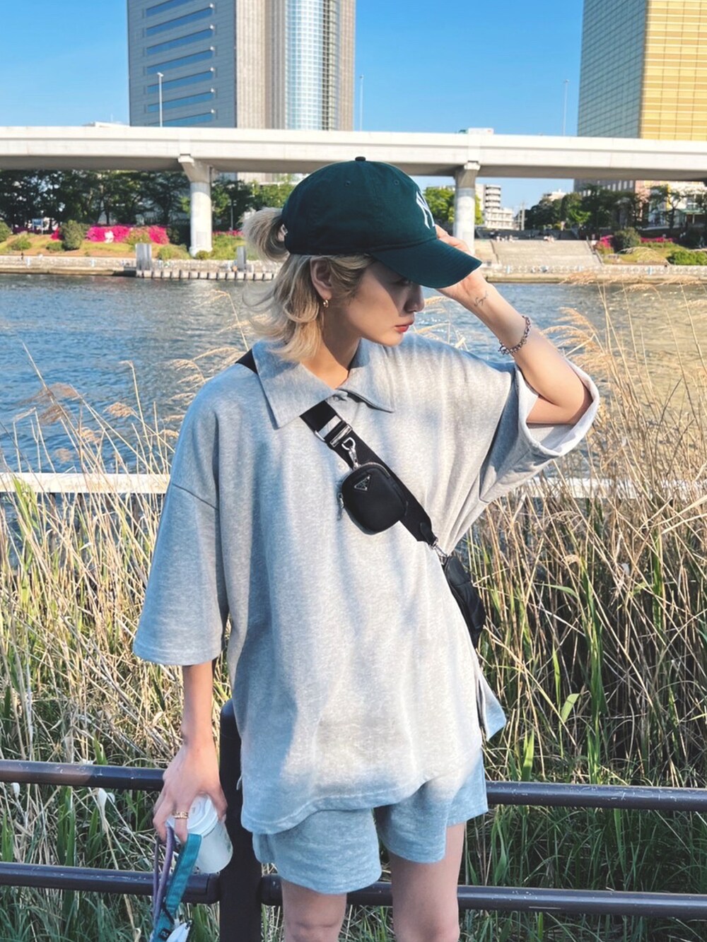 グレー系のポロシャツを着用したレディースの春コーディネートの2枚目の写真