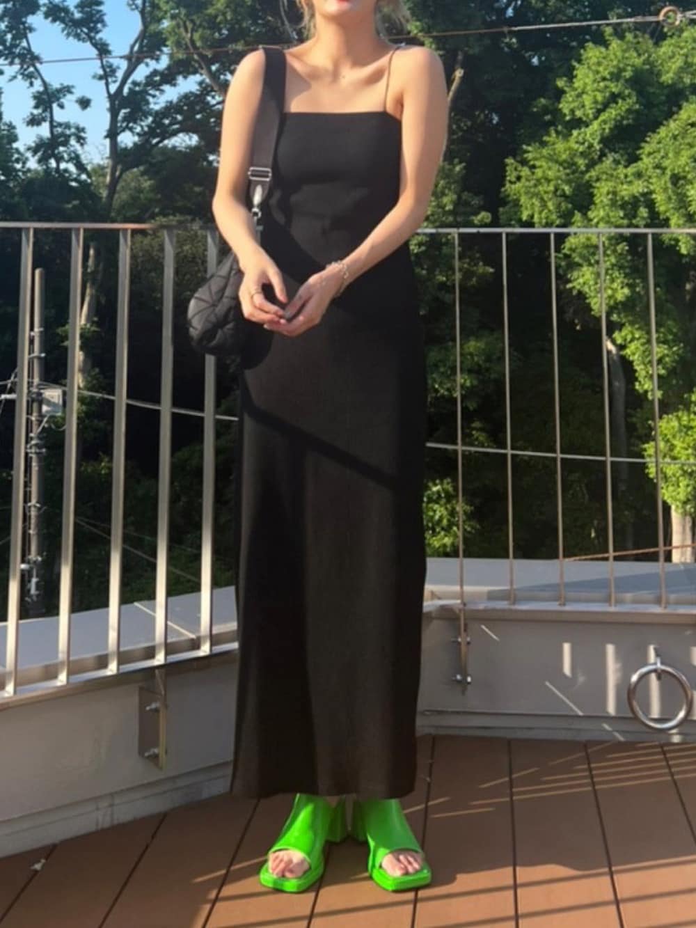 ブラック系のワンピース、グリーン系のサンダルを着用したレディースの夏コーディネートの2枚目の写真