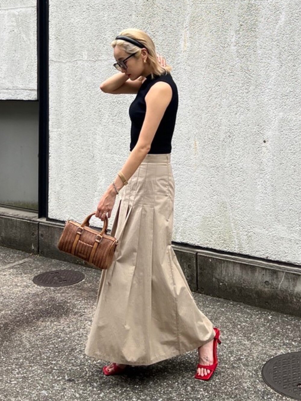 ブラック系のタンクトップ、ブラウン系のショルダーバッグ、レッド系のサンダルを着用したレディースの夏コーディネートの3枚目の写真