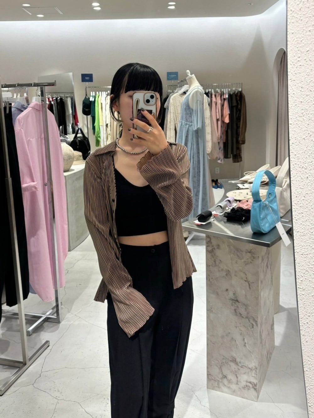 ブラウン系のシャツ/ブラウス、ブラック系のスラックス、ブラック系のローファーを着用したレディースの夏コーディネートの2枚目の写真