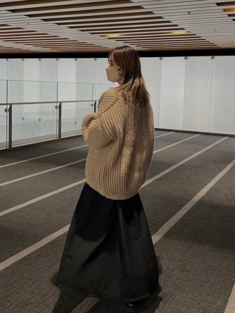 ベージュ系のカーディガン/ボレロを着用したレディースの冬コーディネートの2枚目の写真