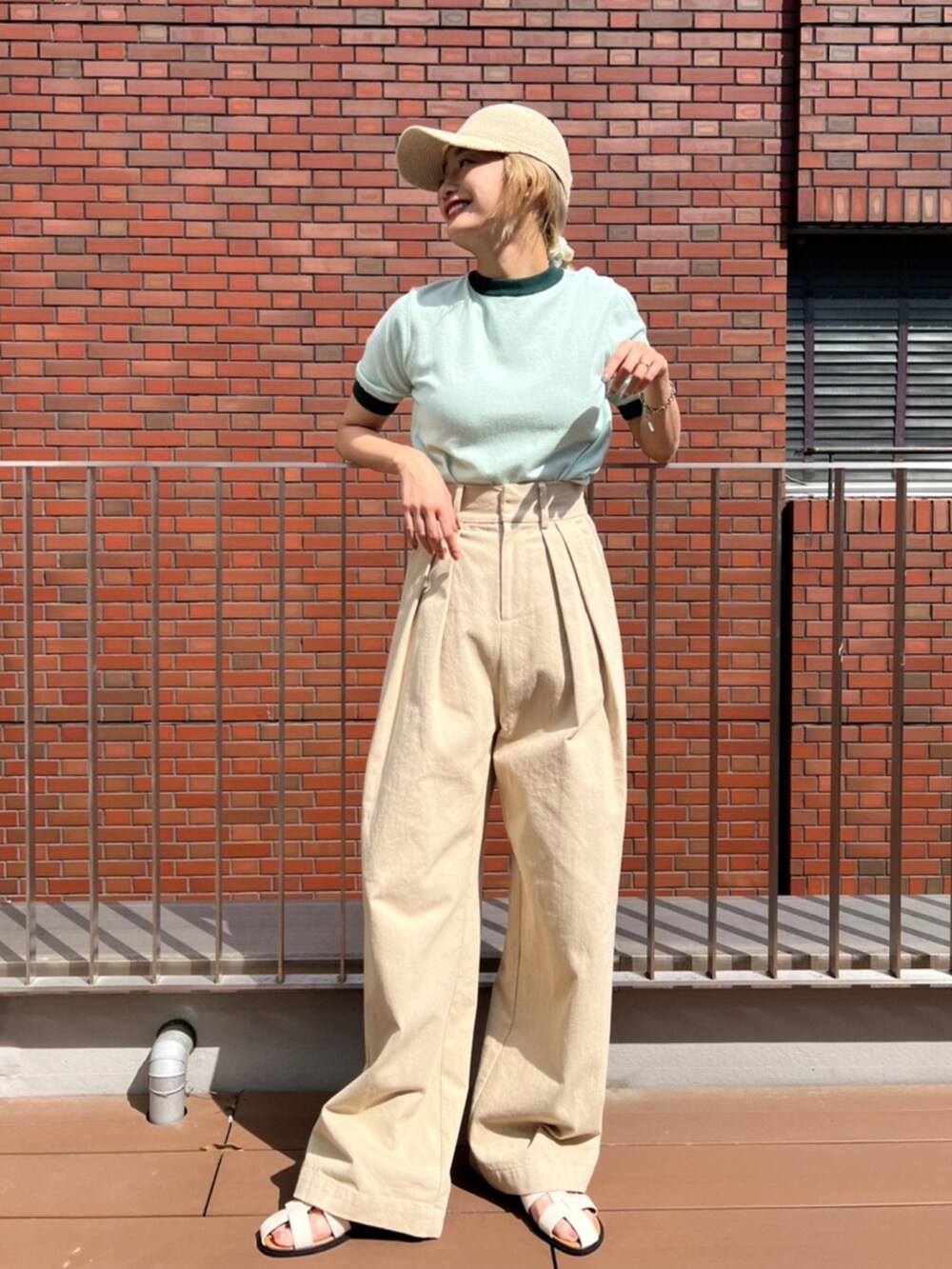 グリーン系のTシャツ/カットソー、ベージュ系のその他パンツ、ホワイト系のサンダルを着用したレディースの春コーディネートの2枚目の写真