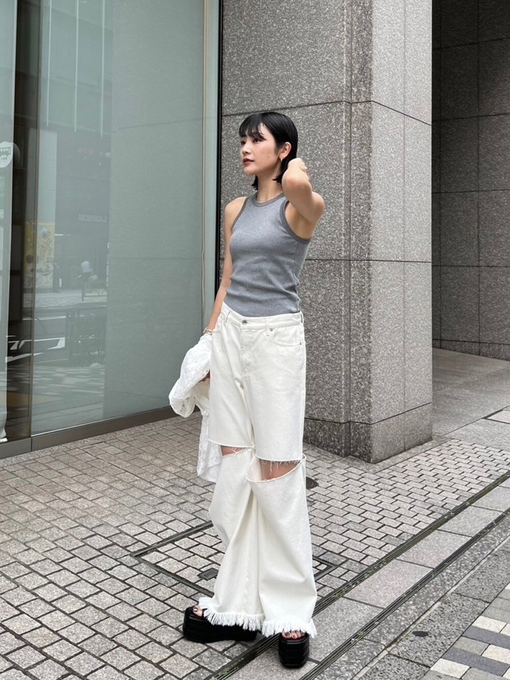 グレー系のタンクトップ、ホワイト系のシャツ/ブラウス、ホワイト系のデニムパンツを着用したレディースの夏コーディネートの2枚目の写真