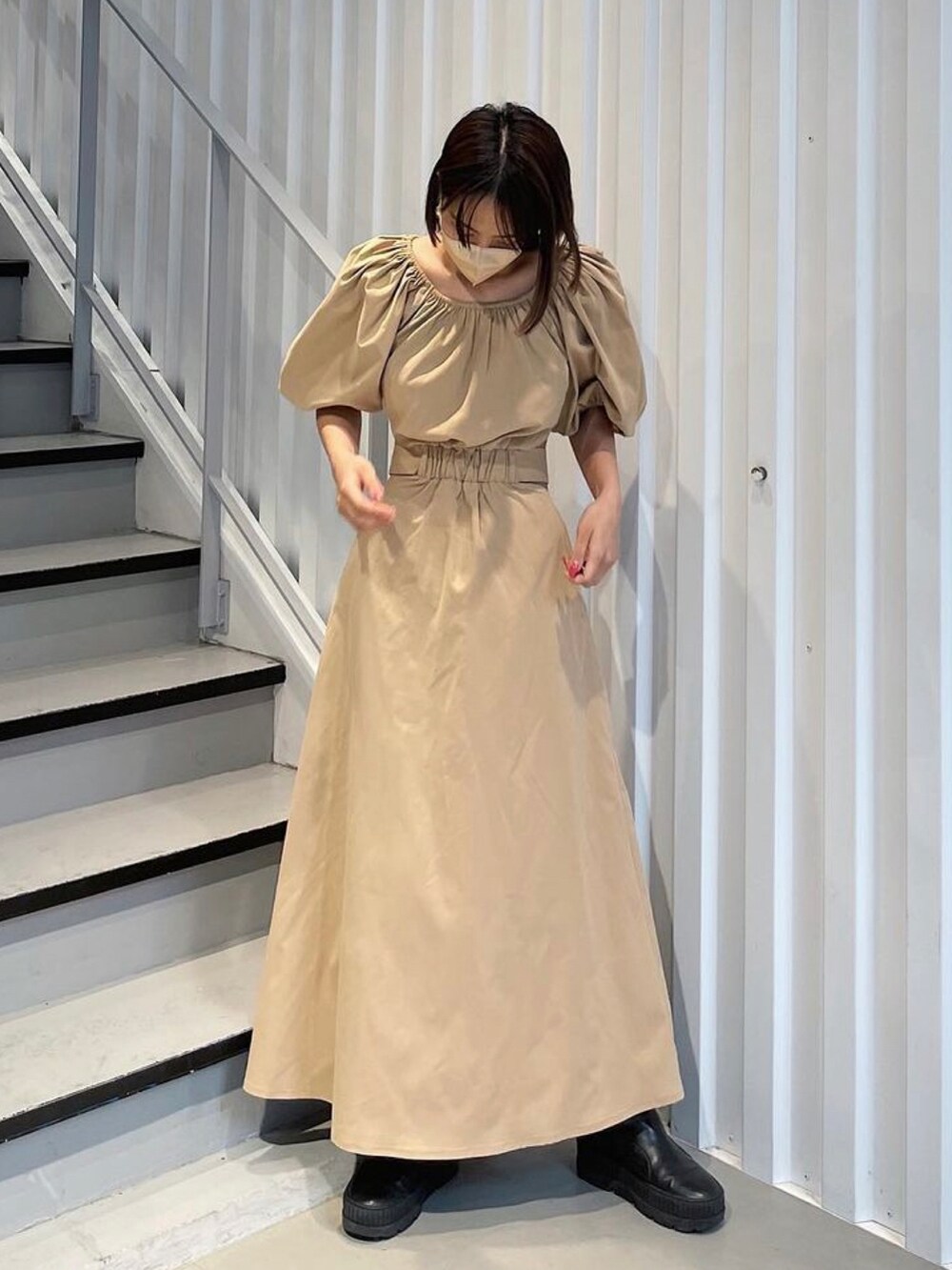 ベージュ系のワンピースを着用したレディースの春コーディネートの2枚目の写真