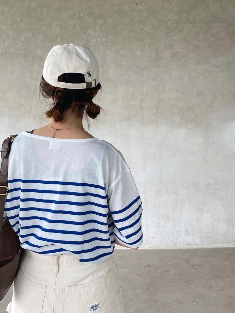 ホワイト系のキャップを着用したレディースの夏コーディネートの2枚目の写真