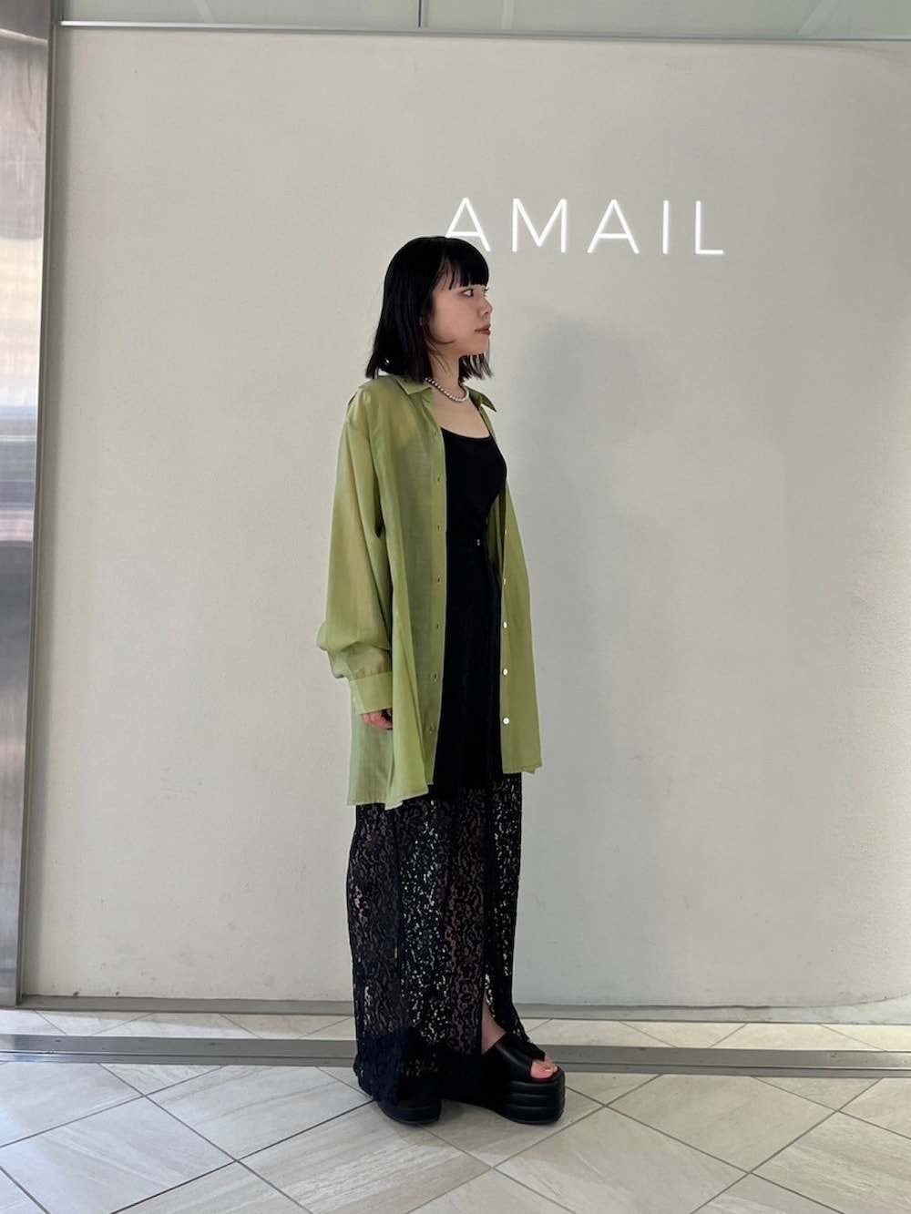 グリーン系のシャツ/ブラウス、ブラック系のサンダル、ブラック系のスカートを着用したレディースの夏コーディネートの3枚目の写真