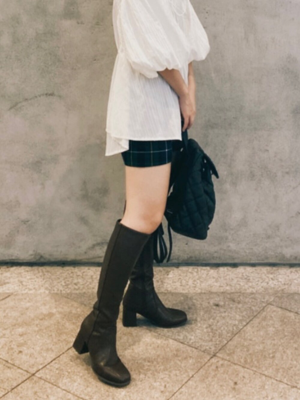 ブラック系のバックパック/リュック、ホワイト系のトップス、グリーン系のカーゴパンツを着用したレディースの秋コーディネートの2枚目の写真