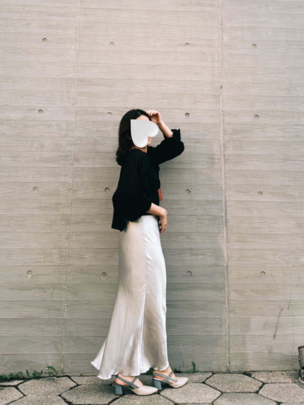 ホワイト系のスカート、オレンジ系のショルダーバッグ、ベージュ系のパンプスを着用したレディースの冬コーディネートの2枚目の写真