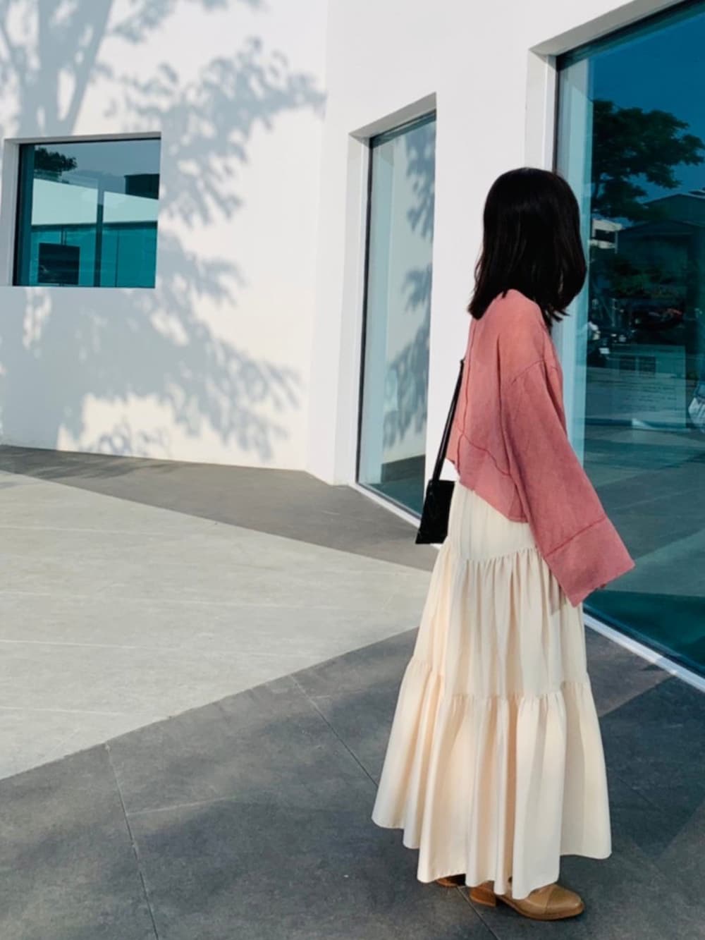 ブラック系のショルダーバッグ、ピンク系のトップスを着用したレディースの冬コーディネートの2枚目の写真