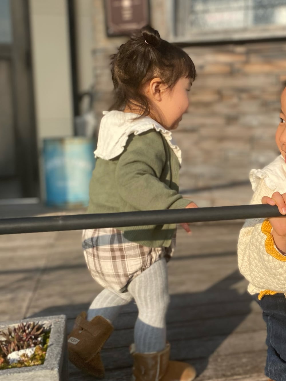ブルー系のデニムパンツ、ブラウン系のブーツ、ブラウン系のシャツ/ブラウスを着用したキッズの冬コーディネートの3枚目の写真