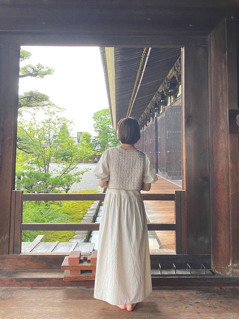 ベージュ系のワンピース、ブラック系のサンダルを着用したレディースの秋コーディネートの2枚目の写真