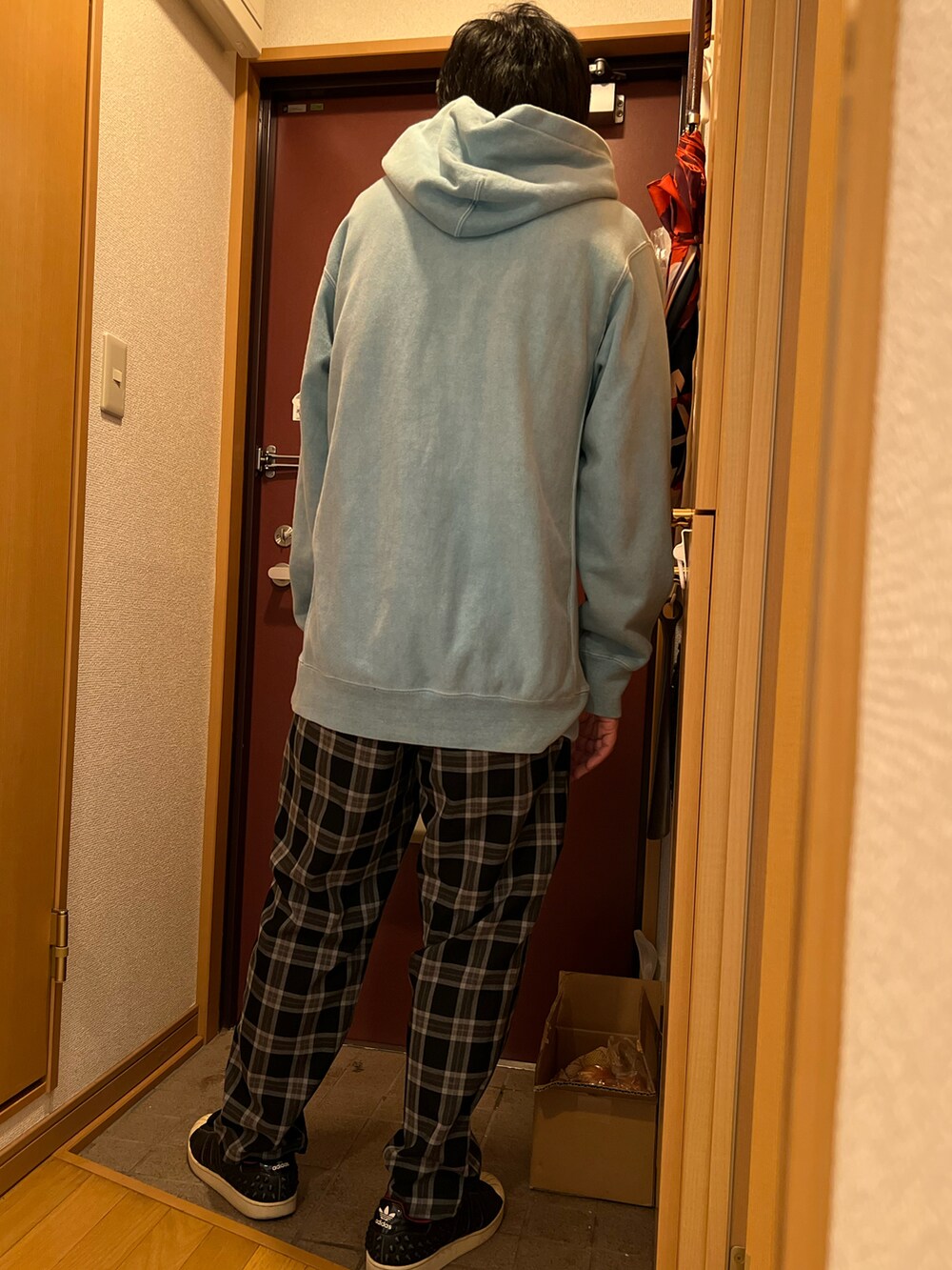 グレー系のパンツ、ブルー系のパーカーを着用したメンズの秋コーディネートの2枚目の写真