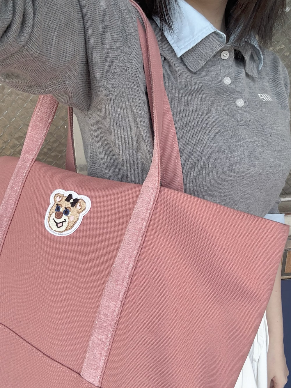 グレー系のニット/セーター、ピンク系のトートバッグを着用したレディースの秋コーディネートの2枚目の写真