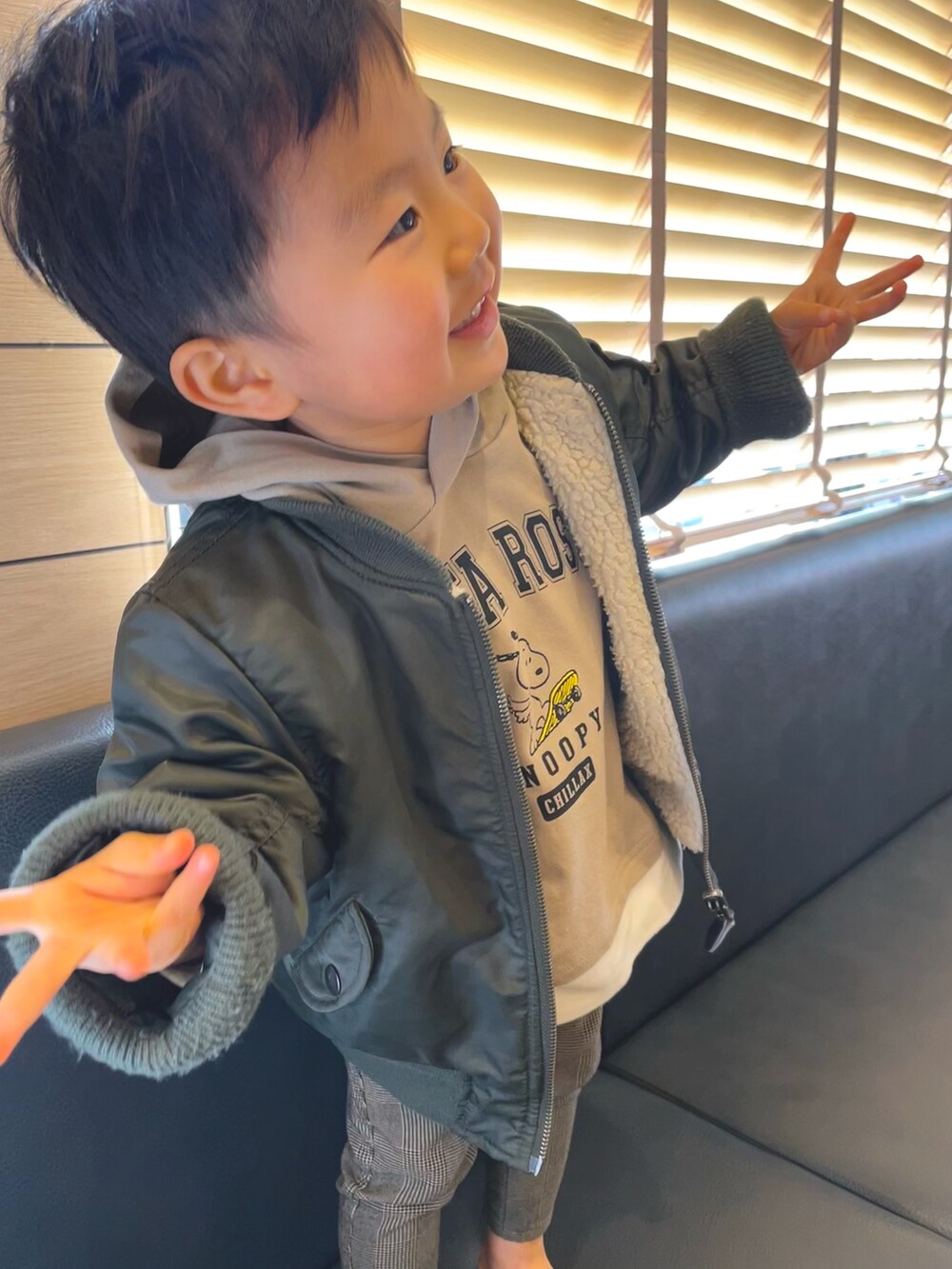 グリーン系のMA-1、ベージュ系のその他パンツ、ブラック系のスニーカーを着用したキッズの冬コーディネートの2枚目の写真