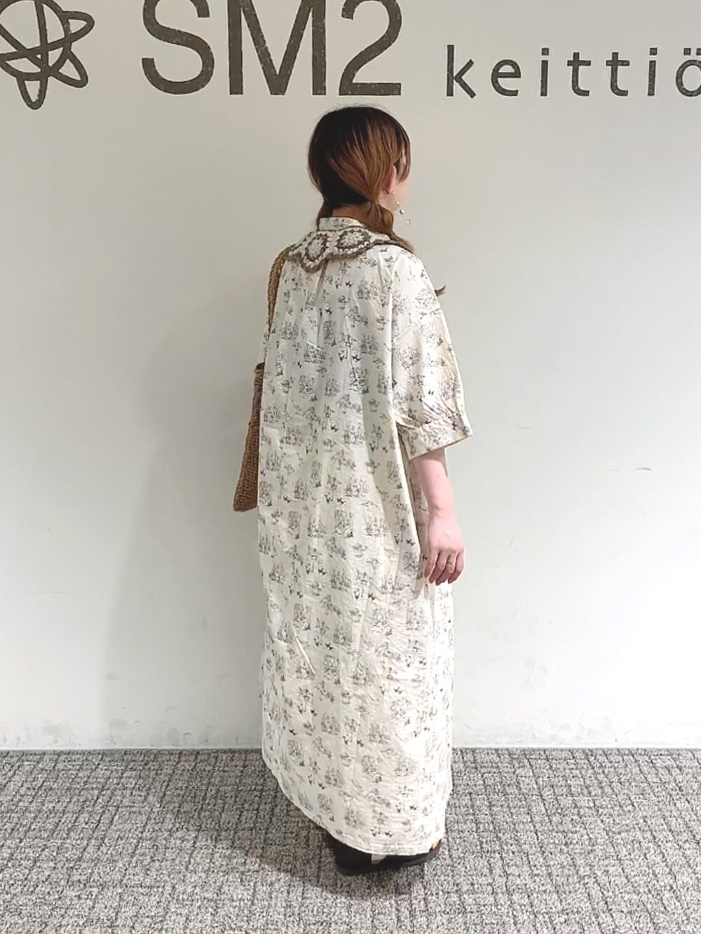 ベージュ系のハンドバッグ、ブラウン系のサンダル、ベージュ系のワンピース/ドレスを着用したレディースの春コーディネートの2枚目の写真