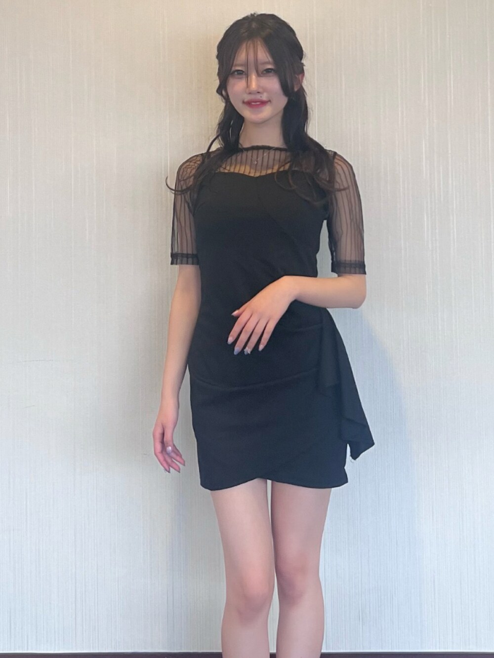 ブラック系のドレスを着用したレディースの春コーディネートの2枚目の写真