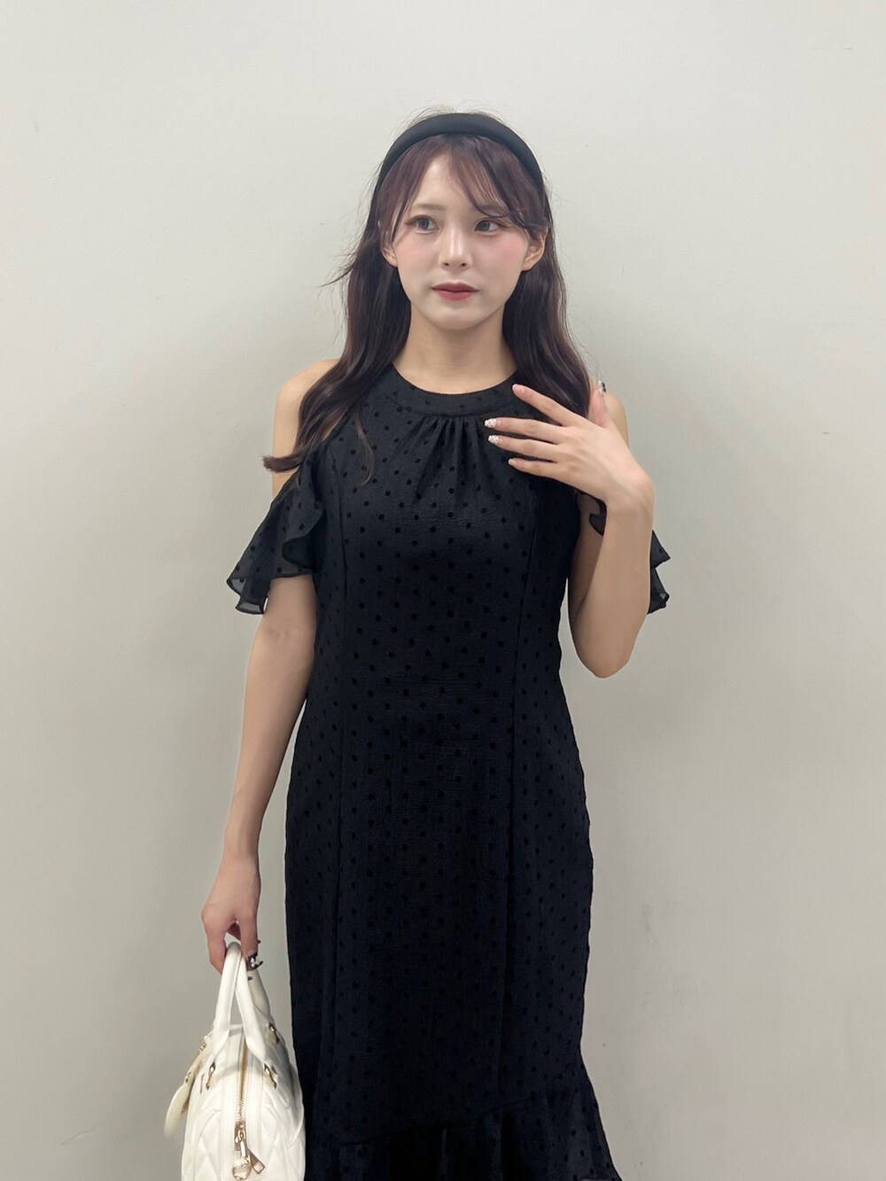 ブラック系のワンピース、ホワイト系のボストンバッグを着用したレディースの夏コーディネートの2枚目の写真