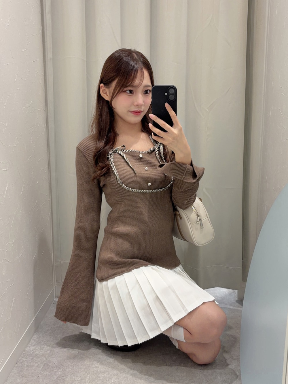 ブラウン系のワンピース、ブラウン系のローファー、ホワイト系のボストンバッグを着用したレディースの秋コーディネートの2枚目の写真