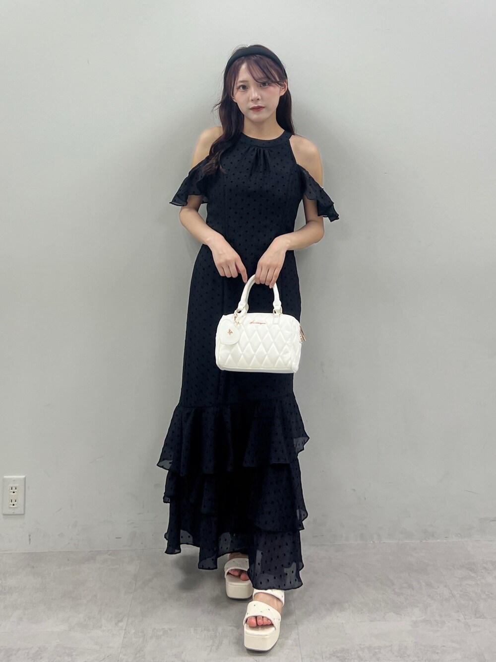 ブラック系のワンピース、ホワイト系のボストンバッグを着用したレディースの夏コーディネートの3枚目の写真