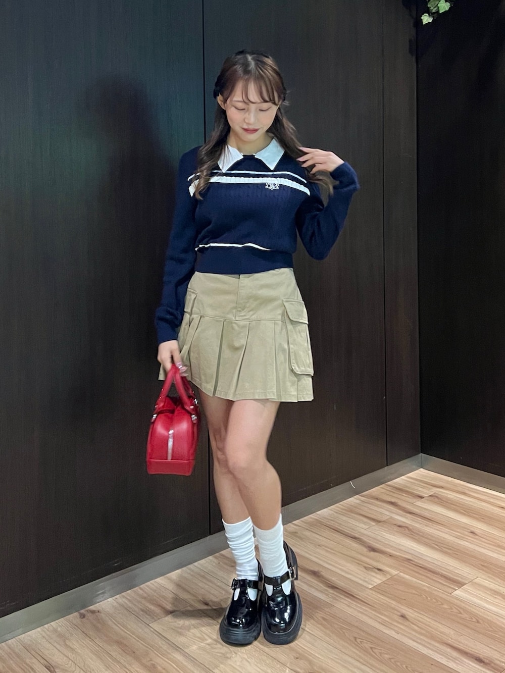ブルー系のニット/セーター、イエロー系のスカート、レッド系のショルダーバッグを着用したレディースの冬コーディネートの2枚目の写真